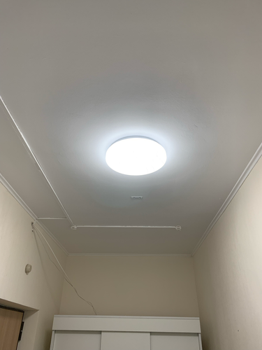 На потолке закреплен светильник с люминесцентными лампами, подключены провода, обеспечено равномерное освещение в помещении. Все элементы надежно установлены и функционируют.