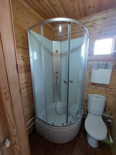 Установлена кабина с низким поддоном: закреплены стенки, подключены коммуникации, проверена герметичность, смонтированы двери, настроен слив, обеспечена устойчивость конструкции.