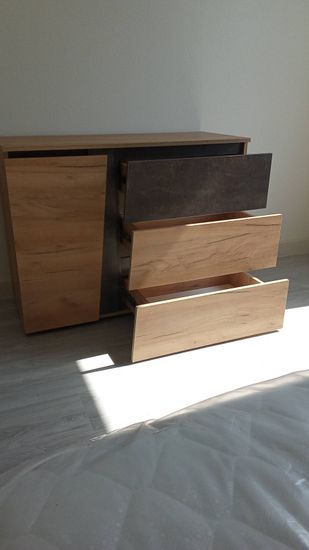 Собран деревянный комод с тремя выдвижными ящиками, установлены направляющие, закреплены фасады, проверена устойчивость конструкции, обеспечена плавность хода ящиков.