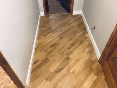 Установлены плинтусы, аккуратно скрывающие стык между стеной и полом. Завершена работа по монтажу, обеспечивающая эстетичный вид и плавный переход. Полностью завершён процесс установки.