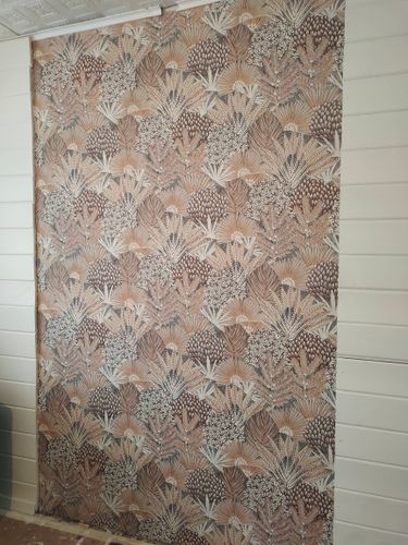 На стене аккуратно наклеены обои с растительным узором, создавая гармоничный и стильный интерьер. Полотно ровно прилегает, без видимых дефектов или пузырей.