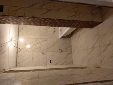 Ванная комната облицована керамогранитом, уложенным на стены и пол. Плитка ровно подогнана, швы аккуратно заделаны, создавая единый стиль. Установлена ванна, подготовлены выводы для сантехники.