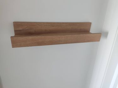 Установлена деревянная полка на стену, обеспечена надежная фиксация. Все элементы соединены аккуратно, конструкция выровнена и готова к использованию.