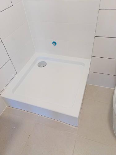 Установлен акриловый поддон, подключен слив, герметично зафиксирован, проверена устойчивость и отсутствие протечек, завершена отделка плиткой вокруг.