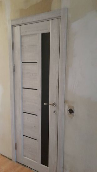 На деревянной двери выполнено аккуратное врезание замка. Установлена ручка, механизм функционирует исправно. Дверь закрывается плавно, без заеданий, обеспечивая надежность.