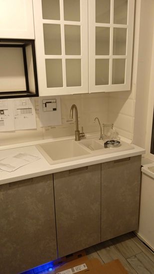 Установлены шкафы, смонтирована столешница, врезана мойка, подключены смесители. Завершена сборка кухонного гарнитура с учётом всех деталей и инструкций.