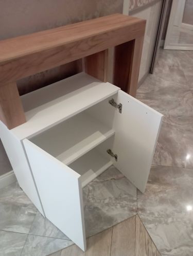 Собран шкаф с двумя дверцами и полкой. Установлены петли, закреплены панели, выровнены элементы. Проведена проверка устойчивости и функциональности.