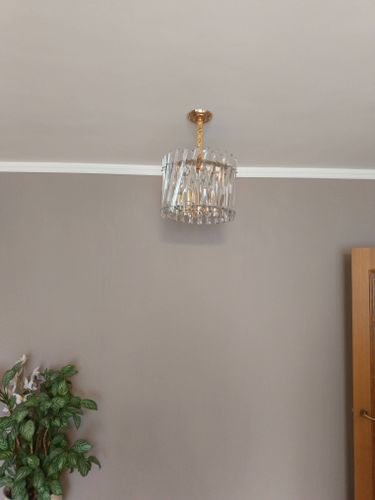 Люстра надежно закреплена на потолке, подключена к электросети, обеспечивая освещение. Все элементы установлены аккуратно, без повреждений поверхности. Завершена проверка работы устройства.