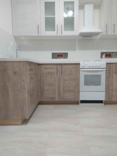 Проведена работа по точному подгонке и установке кухонной поверхности, обеспечивающей идеальное прилегание к шкафам и стенам. Завершено аккуратное оформление углов и краев.