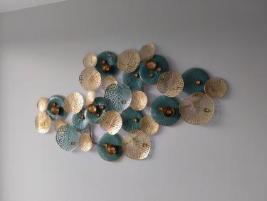 На стене закреплена декоративная композиция из металлических элементов с узорами, создающая стильный акцент в интерьере.