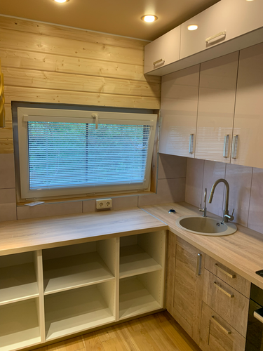 Установлены шкафы, закреплены фасады, смонтирована столешница, врезана мойка, подключен смеситель. Проведены работы по сборке и установке кухонных элементов, включая навеску верхних модулей.