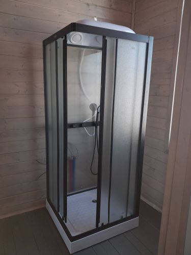 Установлена современная душевая кабина с прозрачными стенками и черной рамой. Проведены работы по подключению сантехники, герметизация швов, монтаж поддона. Обновлен интерьер ванной комнаты.