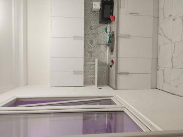 Стены кухни оклеены светлыми обоями, создающими свежий и аккуратный вид. Поверхность ровная, без видимых швов и пузырей, что придаёт помещению завершённый и стильный облик.