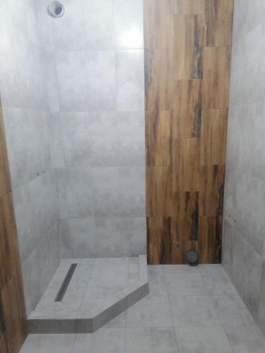 Плитка уложена на стены и пол, создавая гармоничное сочетание текстур. Углы и стыки обработаны, обеспечивая ровную поверхность. Душевой поддон облицован, установлен слив.