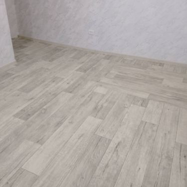 На ровное основание уложено покрытие, тщательно разглажено, подогнано по краям, зафиксировано, стыки аккуратно соединены, обеспечена ровная поверхность без дефектов.