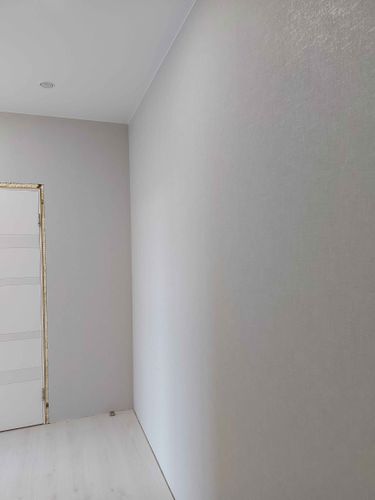 На стенах аккуратно наклеены светлые обои, создающие ровное и гладкое покрытие. Завершенная работа придает помещению свежий и современный вид, гармонично сочетается с интерьером.