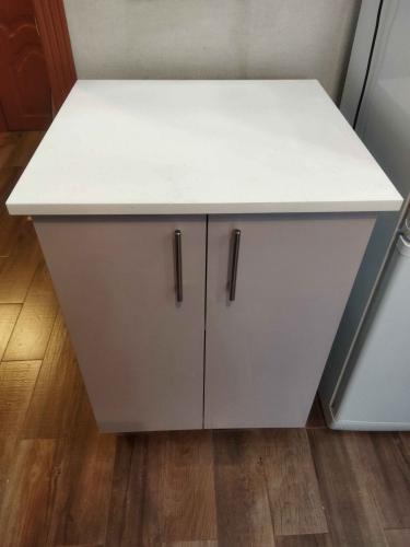 Установлена новая белая столешница на кухонный шкаф, поверхность ровная, аккуратно подогнана, надежно закреплена, швы незаметны, гармонично вписывается в интерьер, завершен монтаж.