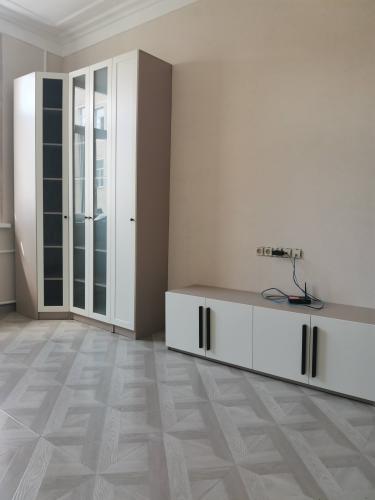 Собрана мебель с дверцами и ручками, установлена на полу. Все элементы надежно закреплены, конструкция выровнена. Пространство организовано для удобного использования.