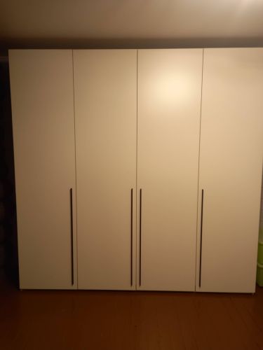 Собран шкаф: установлены панели, прикреплены дверцы, закреплены ручки, выровнена конструкция, проверена устойчивость, отрегулированы петли, завершена сборка.