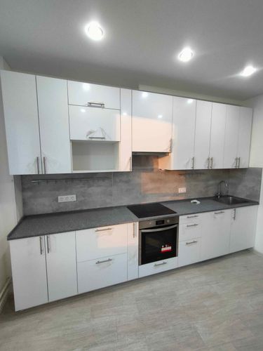 Установлена новая кухонная поверхность из искусственного камня, идеально подогнанная по размерам. Аккуратно выполнены стыки, установлена мойка и варочная панель, обеспечена функциональность.