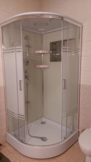 Смонтирована современная душевая конструкция с функцией гидромассажа. Подключены все коммуникации, установлены стеклянные панели, герметизация швов завершена.