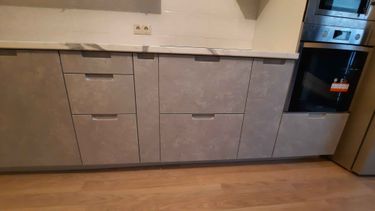 Установлены шкафы, прикреплена столешница, смонтирована техника, выровнены фасады, закреплены ручки, подключены коммуникации, выполнена подгонка элементов, завершена отделка.