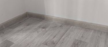 Завершена укладка покрытия на ровное основание, выполнены стыки, установлены плинтусы. Поверхность гладкая, без дефектов, гармонично сочетается с интерьером помещения.