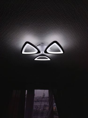 Люстра закреплена на натяжном потолке, подключены провода, проверена работа освещения, обеспечена надежная фиксация, аккуратный монтаж без повреждений поверхности, завершена установка.