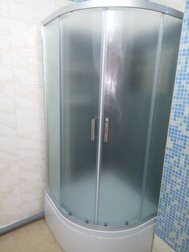 Установлена кабина с низким поддоном, закреплены стенки, смонтированы двери, подключены коммуникации, проверена герметичность, выполнена настройка системы, завершены отделочные работы.