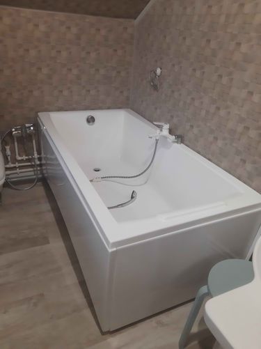 Установлена новая акриловая ванна, подключены водопроводные трубы, закреплены смеситель и слив, герметизированы стыки, проверена герметичность соединений, завершены отделочные работы.