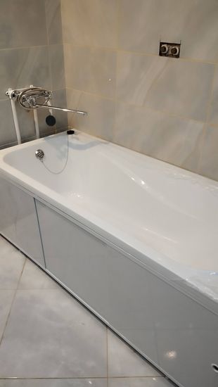 Ванна установлена, подключены трубы, закреплены смеситель и слив, герметизация швов завершена, облицовка стен плиткой выполнена, проверена герметичность соединений, произведена чистка.