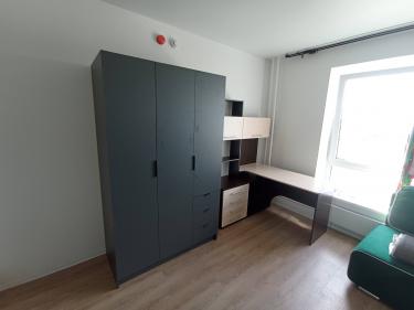 Собран угловой стол с ящиками и полками, установлен у окна. Все элементы надежно закреплены, обеспечена устойчивость конструкции. Завершена установка без видимых дефектов.