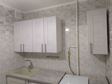 Изображение демонстрирует завершённый процесс разборки кухонных шкафов, снятие настенных панелей, отключение сантехники и электроприборов, освобождение пространства для последующего обновления интерьера.