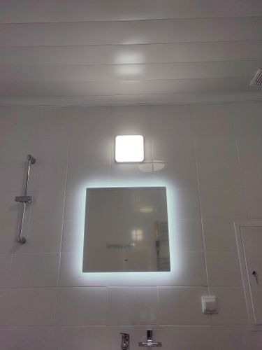 Зеркало надежно установлено на стене, подключена подсветка, выровнено по уровню, закреплено крепежами, обеспечена безопасность и эстетичность, завершено оформление интерьера ванной комнаты.