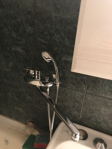 Изображение демонстрирует завершенный процесс удаления смесителя с раковины. Все элементы аккуратно отсоединены, поверхность очищена от остатков герметика и грязи.