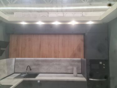 Обновлены дверцы шкафов, установлены новые панели с древесной текстурой, заменены ручки, улучшен внешний вид, добавлено освещение, обновлён интерьер, улучшена функциональность, повышена эстетика.