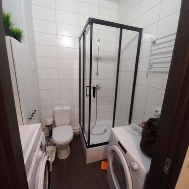 Ванная комната обновлена: смонтирована стеклянная конструкция с дверцами, поддон установлен, подключен смеситель, герметизация швов завершена. Все элементы надежно закреплены.