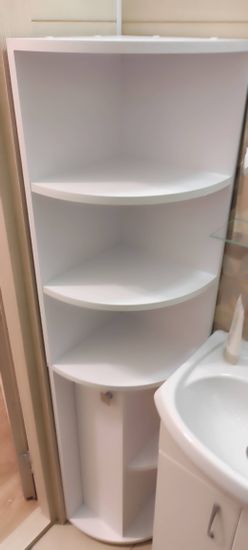 Собран угловой шкаф с полками, установлен в ванной комнате. Все детали аккуратно соединены, дверца ровно навешена, ручка закреплена. Конструкция устойчивая, готова к использованию.