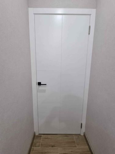 Установлены аккуратные белые наличники, плотно прилегающие к дверной раме. Все стыки ровные, без зазоров, создают завершенный вид. Эстетично оформленный проем гармонирует с интерьером.