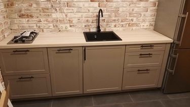 Установлены шкафы, закреплена столешница, подключена мойка и смеситель, установлена варочная панель. Все элементы аккуратно выровнены и надежно зафиксированы.