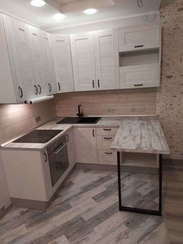 Готовая кухня с установленной столешницей, идеально подогнанной под размеры. Поверхность аккуратно обработана, углы выровнены, обеспечена точная подгонка к стенам и мебели.