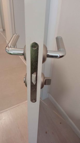 Установлен новый замок в деревянную дверь. Выполнено сверление отверстий, монтаж механизма, закрепление ручек и проверка работоспособности. Все элементы надежно зафиксированы.