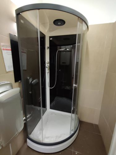 Установлена современная душевая конструкция с низким основанием, герметично закреплены стеклянные панели, подключены водопроводные коммуникации, проверена функциональность смесителя и лейки.