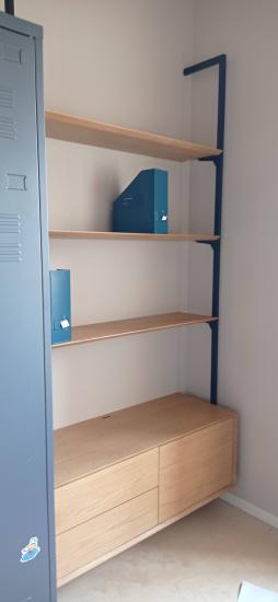 Собран деревянный шкаф с тремя полками и двумя ящиками. Установлены крепления, обеспечивающие устойчивость конструкции. Все детали подогнаны и закреплены, обеспечивая функциональность.