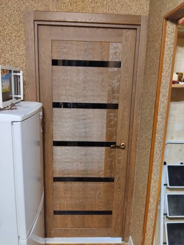 Установлена дверь с коробкой, закреплены петли, врезан замок, отрегулирована створка, обеспечена плавная работа, выполнена отделка наличниками, проверена герметичность.