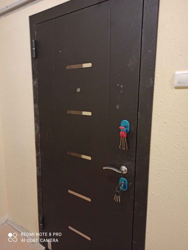 Изображена установленная пластиковая дверь. Проведены работы по монтажу, выравниванию и закреплению конструкции. Установлены ручки и замки, проверена функциональность.