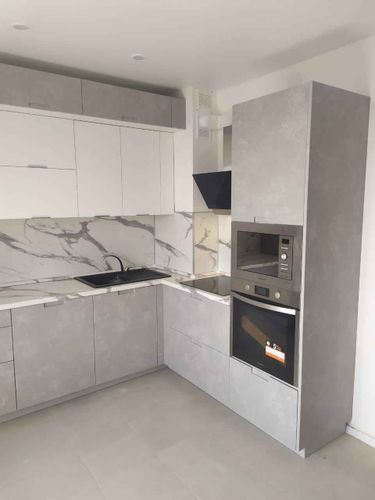 Собрана кухня: установлены шкафы, закреплены фасады, смонтирована столешница, встроена техника, подключена мойка, установлены ручки, выполнена подгонка элементов, завершена отделка.