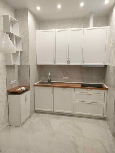 Установлены шкафы, смонтирована столешница, врезана мойка, подключена варочная панель, закреплены полки, проведены коммуникации, установлены ручки, завершена отделка стен.