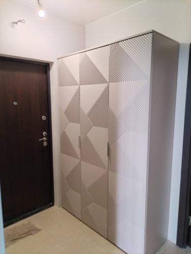 Собран шкаф с геометрическим узором, установлены двери, закреплены ручки. Все элементы тщательно выровнены и зафиксированы для надежности и долговечности конструкции.