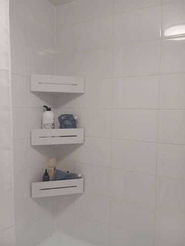 Установлены три белые полки в углу ванной комнаты на кафельной стене. Полки надежно закреплены, на них размещены различные предметы для ухода. Работа выполнена аккуратно и качественно.